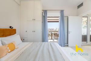 雅典Athenian Sky Retreat: Jacuzzi & Fresh Elegance!的一间卧室设有一张床,并有通往阳台的门