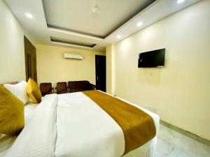 新德里Hotel Saket Place - Near Saket Metro的一间卧室配有一张床和一台平面电视