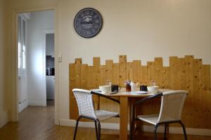 拉罗谢尔阿里泽亚酒店的一张桌子,两把椅子和墙上的时钟
