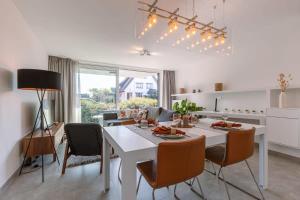布兰肯贝赫Luxuriously appointed apartment with lovely terrace and private parking的厨房以及带白色桌椅的用餐室。