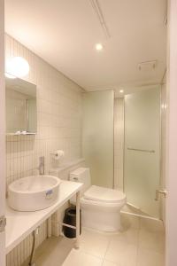 首尔上流旅馆的白色的浴室设有水槽和卫生间。