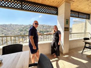 安曼Villa Mira GuestHouse 2 - Downtown Central Amman - AL DIYRIH的站在阳台上的男女