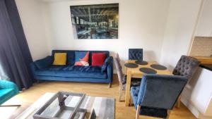 伦敦Garland Central City Apartment London 2的客厅配有蓝色的沙发和桌子