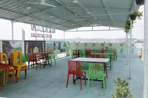 奥兰加巴德Hotel Karan International ,Aurangabad的餐厅内的露台配有五颜六色的桌椅
