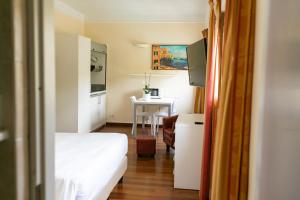 热那亚雷克斯公寓酒店的小房间设有一张床和一张桌子