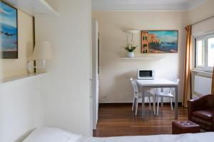 热那亚雷克斯公寓酒店的一间卧室配有一张桌子,上面有一台笔记本电脑