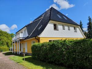HirschburgFerienwohnung NH14的黄色和白色的黑屋顶房子