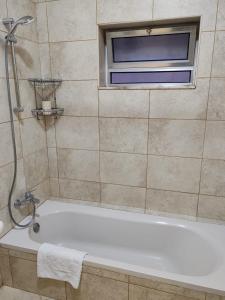 马达巴CMK Housing的带浴缸的浴室和窗户。