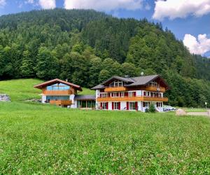 奥伯斯特多夫Alpenlodge Charivari - SommerBergBahn unlimited kostenlos的一座带绿地的山丘上的大型房屋