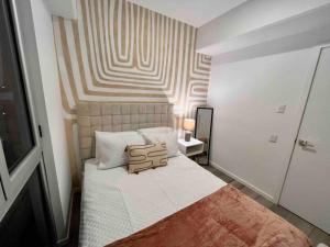 危地马拉Ua ua - Comfortable apartment的一间卧室配有一张带条纹墙的床