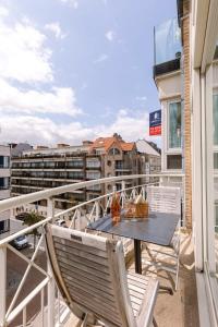 克诺克－海斯特Lovely and spacious apartment on top location in Knokke的阳台配有桌椅。