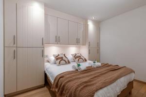 克诺克－海斯特Lovely and spacious apartment on top location in Knokke的一间卧室配有一张带白色橱柜的大床
