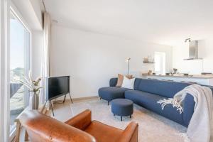 布鲁日Brand new apartment with stunning harbor views的客厅配有蓝色的沙发和电视