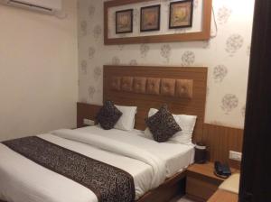 艾哈迈达巴德HOTEL RK PALACE的卧室配有一张带白色床单和枕头的大床。