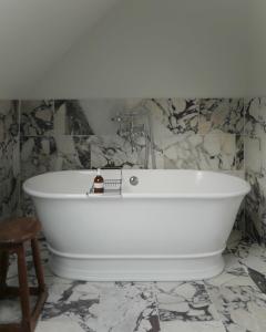 巴拉特Oldschool - Exclusive house surrounded by a dyke的浴室设有白色浴缸,拥有大理石墙壁。