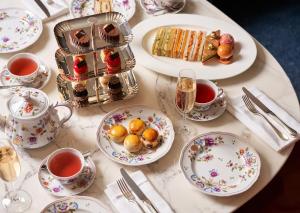 伦敦Bulgari Hotel London的餐桌,盘子上放着食物和茶杯