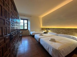仕格莱Albergue Real Fabrica de Ezcaray的酒店客房设有两张床和窗户。