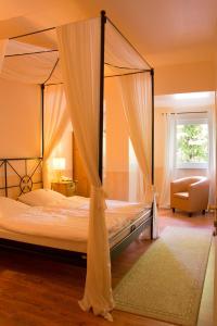 杰斯帝堡耶格尔酒店的一间卧室配有一张天蓬床和一把椅子