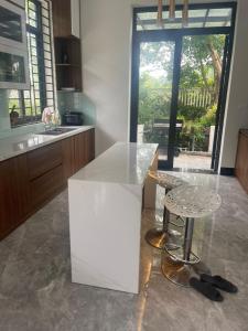 Nam GiaoResort Xanh Villa 5 Stars的厨房配有柜台、桌子和凳子