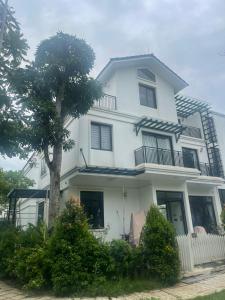 Nam GiaoResort Xanh Villa 5 Stars的前面有一棵树的白色房子