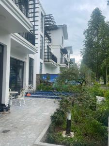 Nam GiaoResort Xanh Villa 5 Stars的白色的建筑,设有带桌椅的庭院