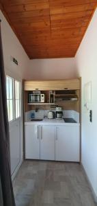 里托楚伦Litochoro Appartment in Estate A2的厨房配有白色橱柜和木制天花板