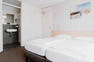 阿赫特克克Hotel Kodde的一间带2张白色床的卧室和一间浴室