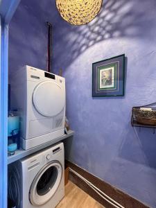 图尔昆Maison Georges的洗衣房配有洗衣机和紫色墙壁