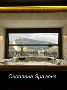 布克维Chalet Fomich的浴缸位于享有美景的窗户前