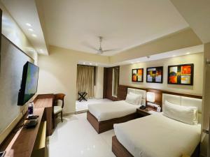 因帕尔三爱大陆精品酒店的酒店客房设有两张床和一台平面电视。