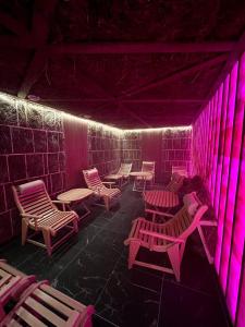 布克维Chalet Fomich的配有桌椅和粉红色灯的房间