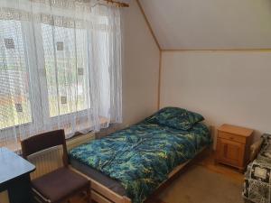 克罗斯诺Beskidy的一间小卧室,配有一张床和一把椅子