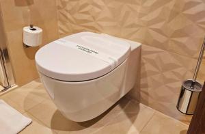 克拉科夫Sky Hotel Kraków的浴室里设有白色的马桶,配有卫生纸