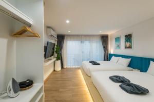 奥南海滩Otter House Aonang Soi 13的一间酒店客房,设有两张床和电视