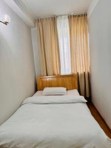 乌兰巴托Khongor Guest house & Tours的一个小房间的一个床位,设有窗户