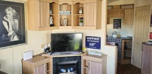 滨海克拉克顿J.R. Holiday Homes的厨房配有壁炉顶部的电视