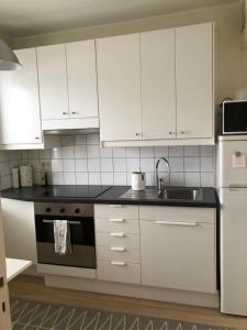 凯米Kemi city center 2 room and kitchen Free private parking的厨房配有白色橱柜、水槽和炉灶。