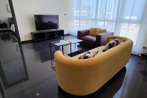 科威特Smart Stay Salmiya apartment的客厅配有黄色沙发和电视