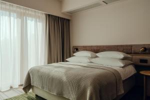 波兹南PURO Hotel Poznań Stare Miasto的卧室配有带白色枕头的大床