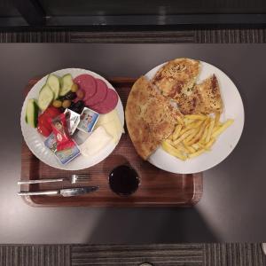 伊斯坦布尔VPLUS HOTEL的盘子,盘子上放着两盘食物和薯条