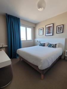 基伯龙波特哈利甘酒店的一间卧室配有一张带蓝色窗帘的大床