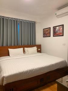 河内A25 Hotel - Đội Cấn 2的一间卧室配有一张带白色床单的大床