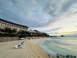 麦克坦Dusit Thani Mactan Cebu Resort的海滩上设有白色躺椅,大海上设有