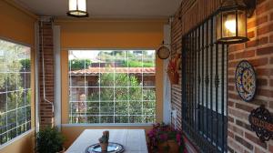 托莱多Casa Rural Dani Escalona的一个带桌子和大窗户的门廊