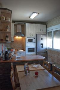托莱多Casa Rural Dani Escalona的厨房配有桌子和炉灶。 顶部烤箱