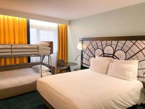 巴黎巴黎凡尔赛门展览中心美居酒店的酒店客房配有一张床和双层床。