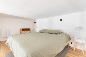 里尔Lille Bel appartement Cosy avec Mezzanine的白色卧室配有一张大床和一张桌子