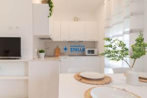利多迪耶索罗Condominio Rossella的白色的厨房配有白色橱柜和水槽