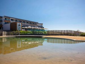 莱萨布勒-多洛讷Côte Ouest Hôtel Thalasso & Spa Les Sables d'Olonne - MGallery的建筑物前的水池