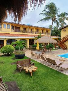 圣若泽-达科罗阿格兰迪Pousada Vivenda Oriente的一个带长椅和游泳池的庭院